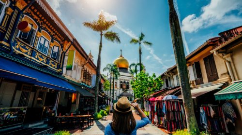 Young woman traveler traveling into The Masjid Sultan mosque located in Kampong Glam in Singapore city.
